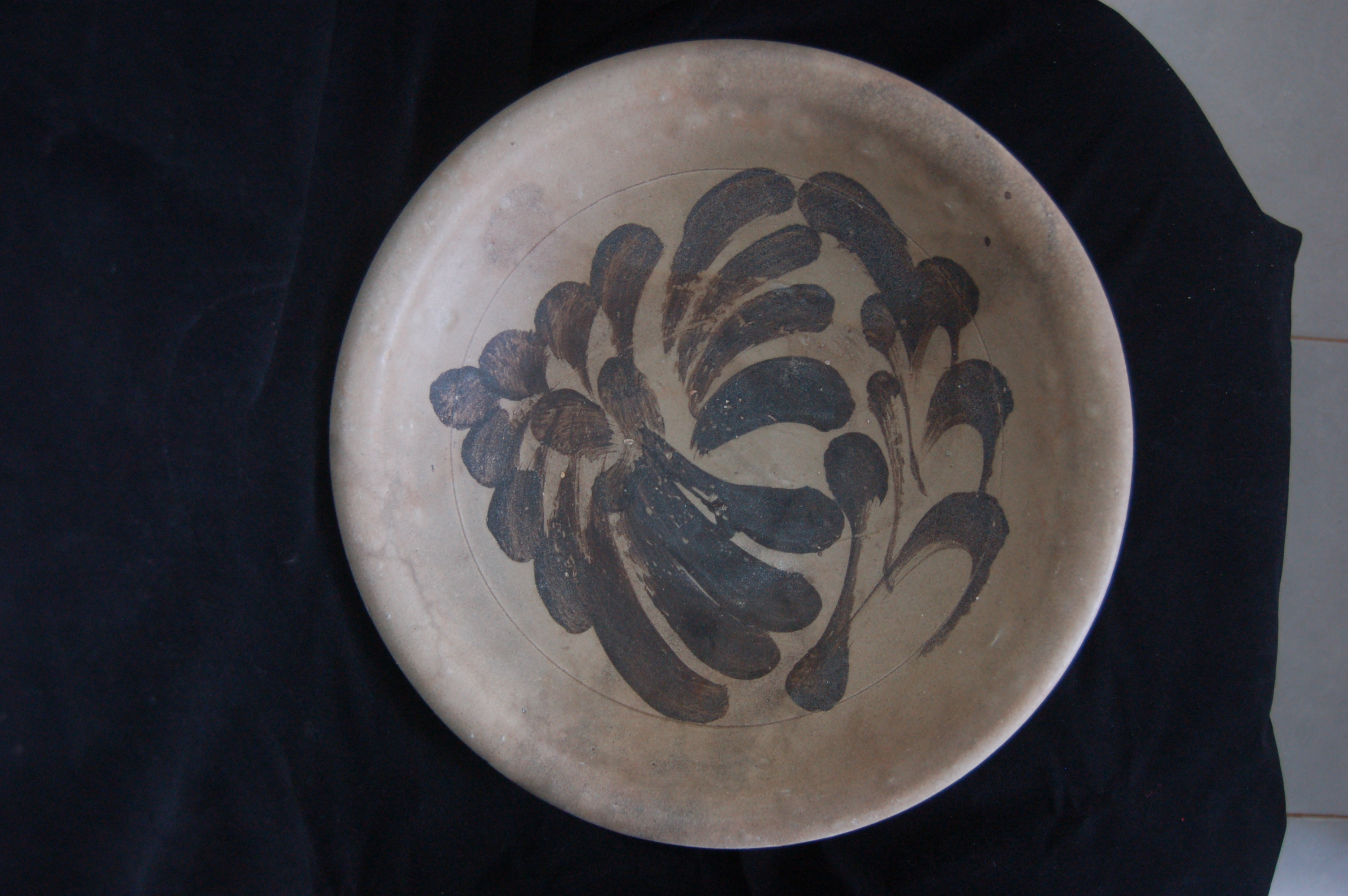 Large shallow bowl with an everted rim and a cursive floral decoration painted in iron-brown. Diameter 33 cm, height 10 cm.