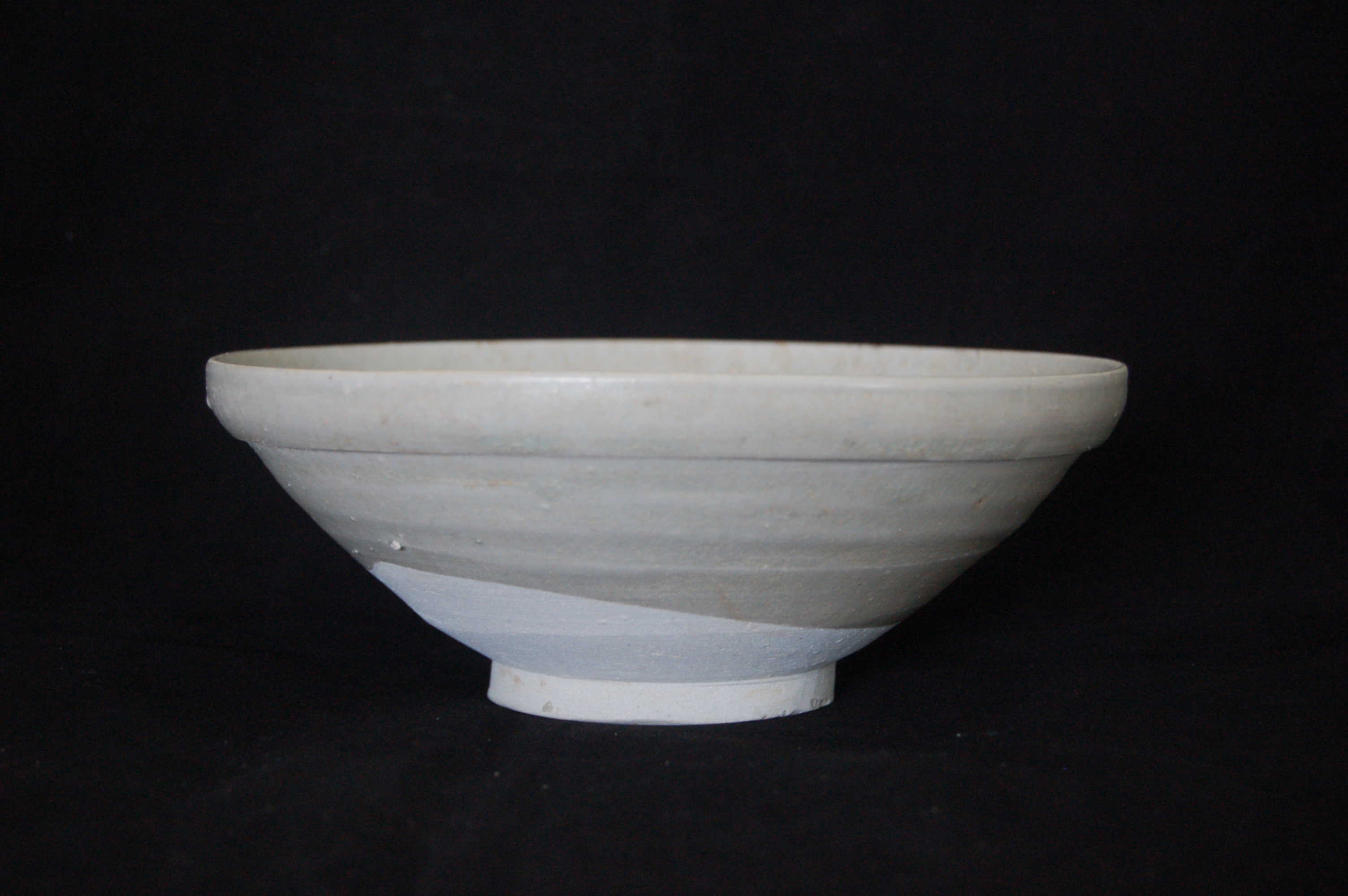 Folded-rim bowl with a slightly rounded wall, an incised ring in the well and a carved foot-ring. Diameter 18 cm, height 7 cm.