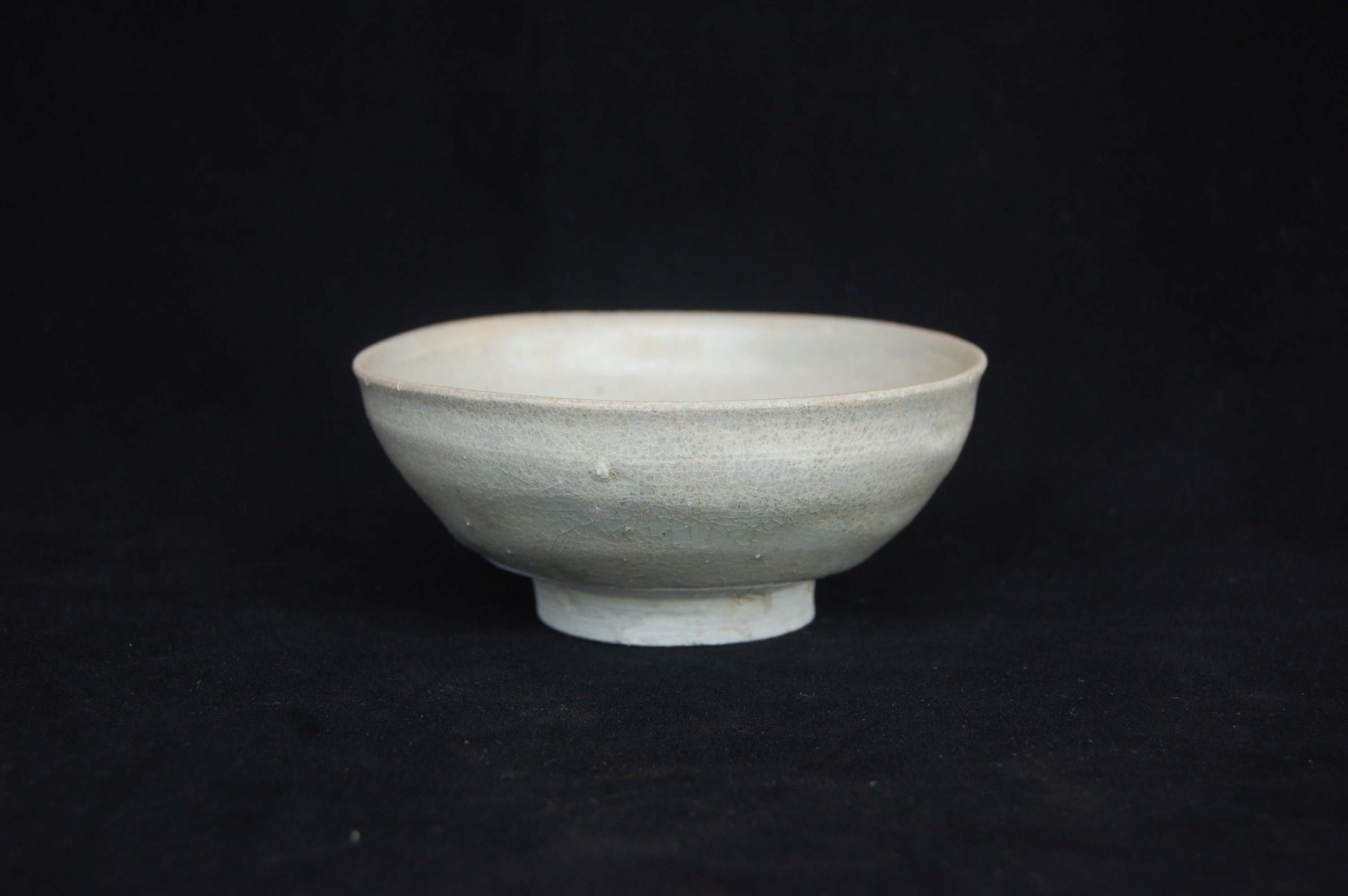 Small plain bowl with a slightly everted rim, round wall and a carved foot-ring. Diameter 12 cm, height 5 cm.