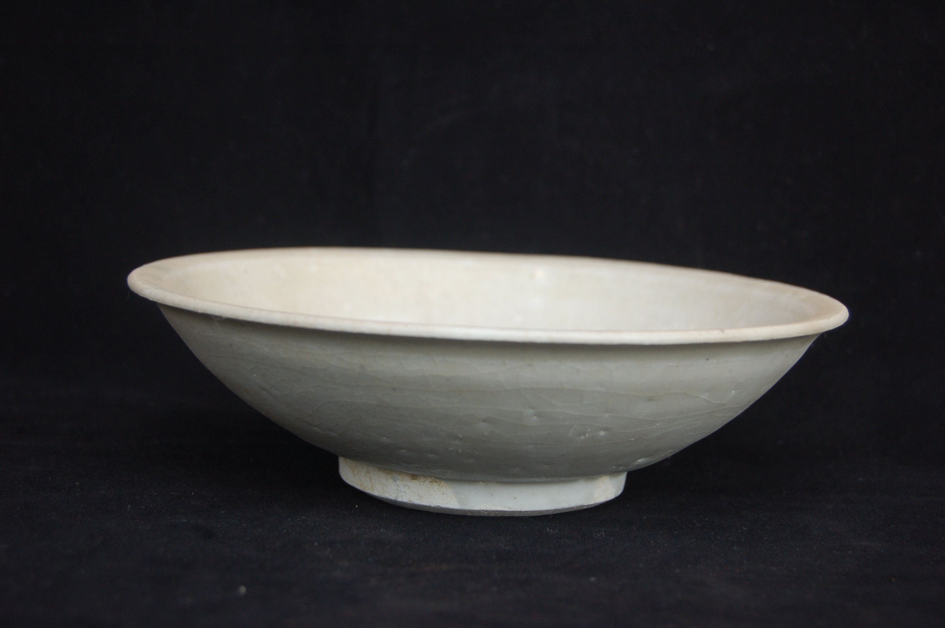 Plain shallow bowl with an everted rim, incised ring in the well, rounded wall and a carved foot-ring. Diameter 19 cm, height 5.5 cm.