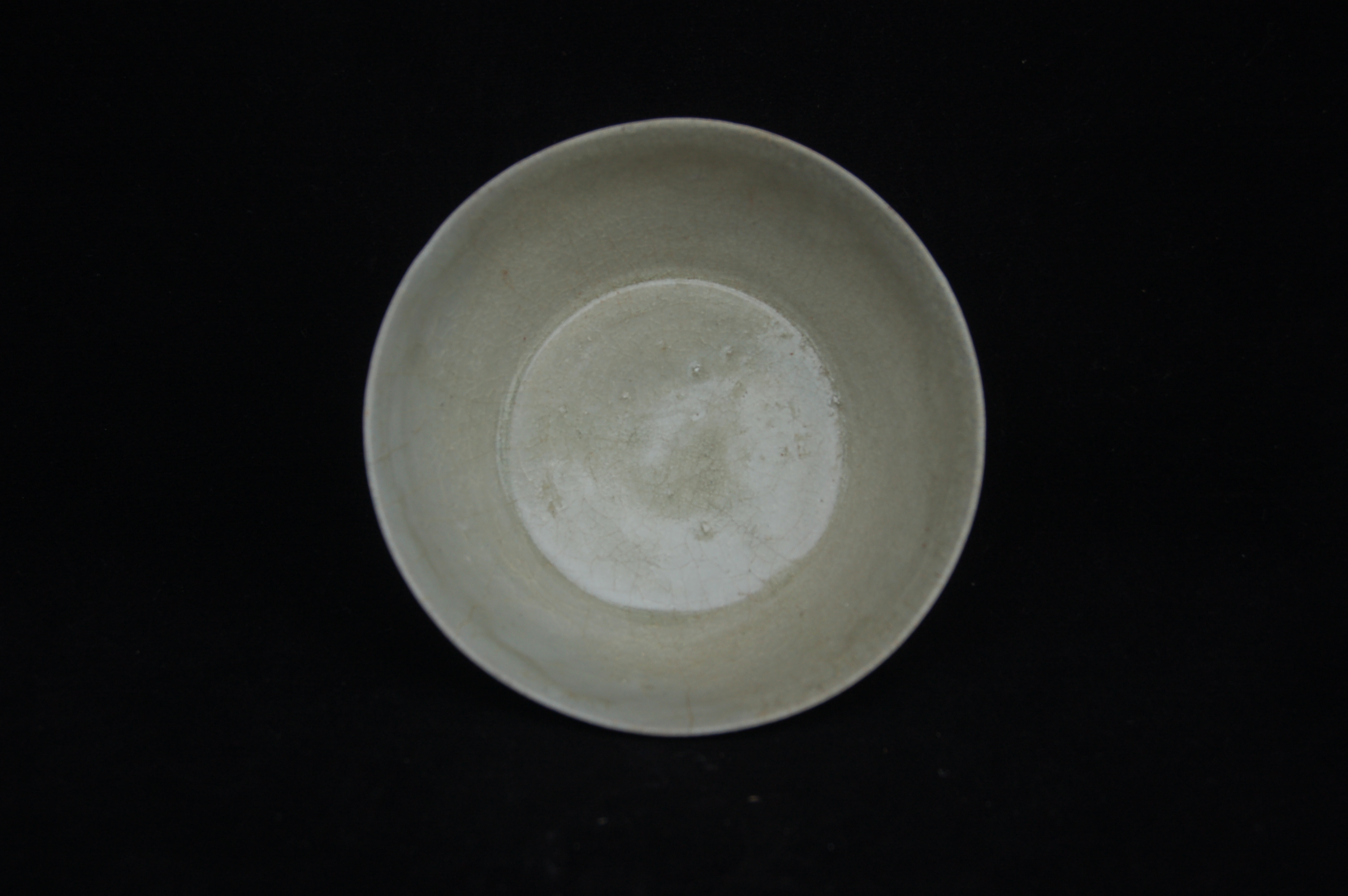 Small bowl with slightly everted rim, rounded wall with incised striations, on a high carved foot-ring. Diameter 12 cm, height 5 cm.