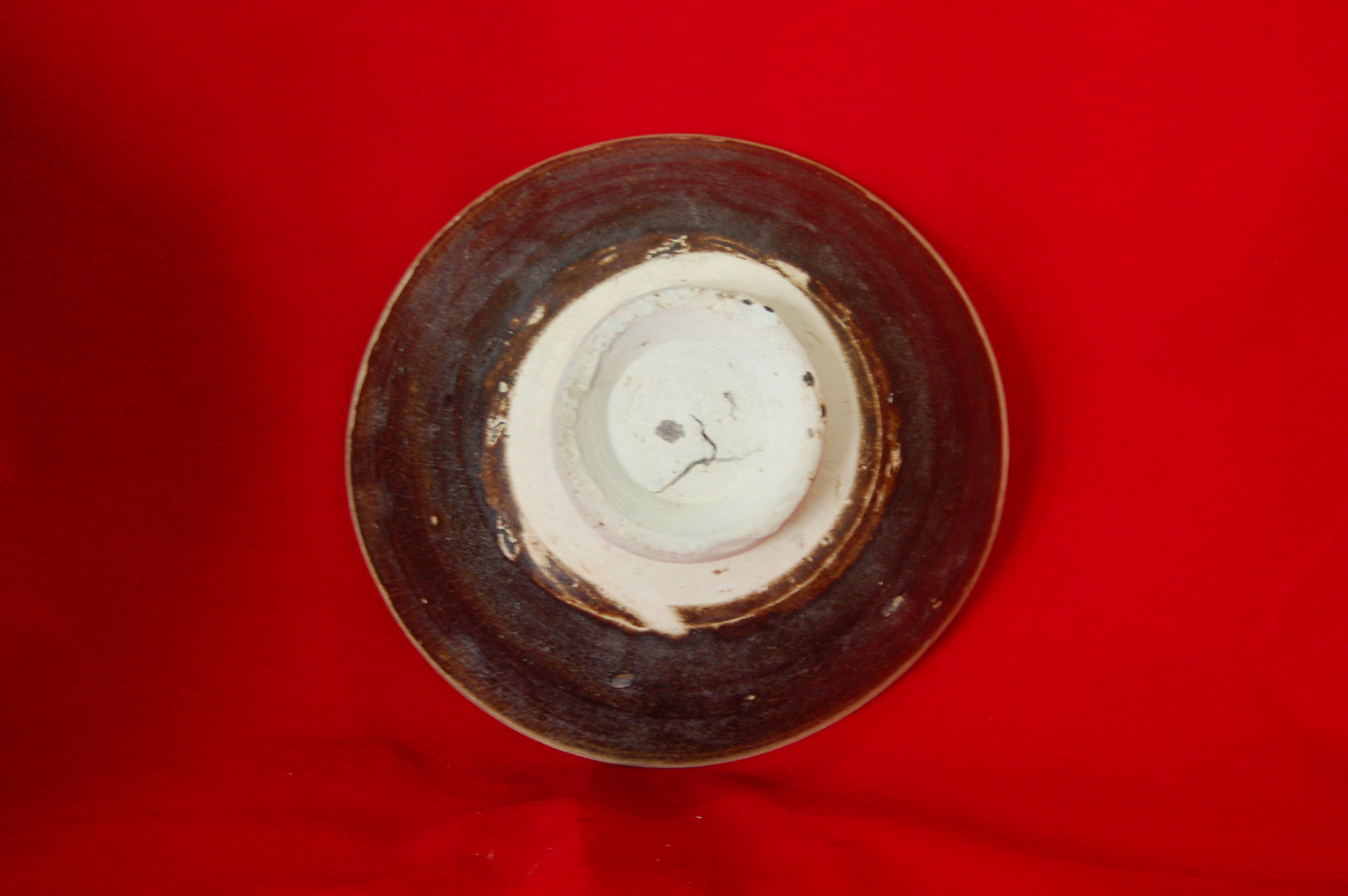<em>Temmoku</em> with straight rim, rounded wall and carved foot-ring. Unglazed rim. Diameter 15 cm, height 7 cm.