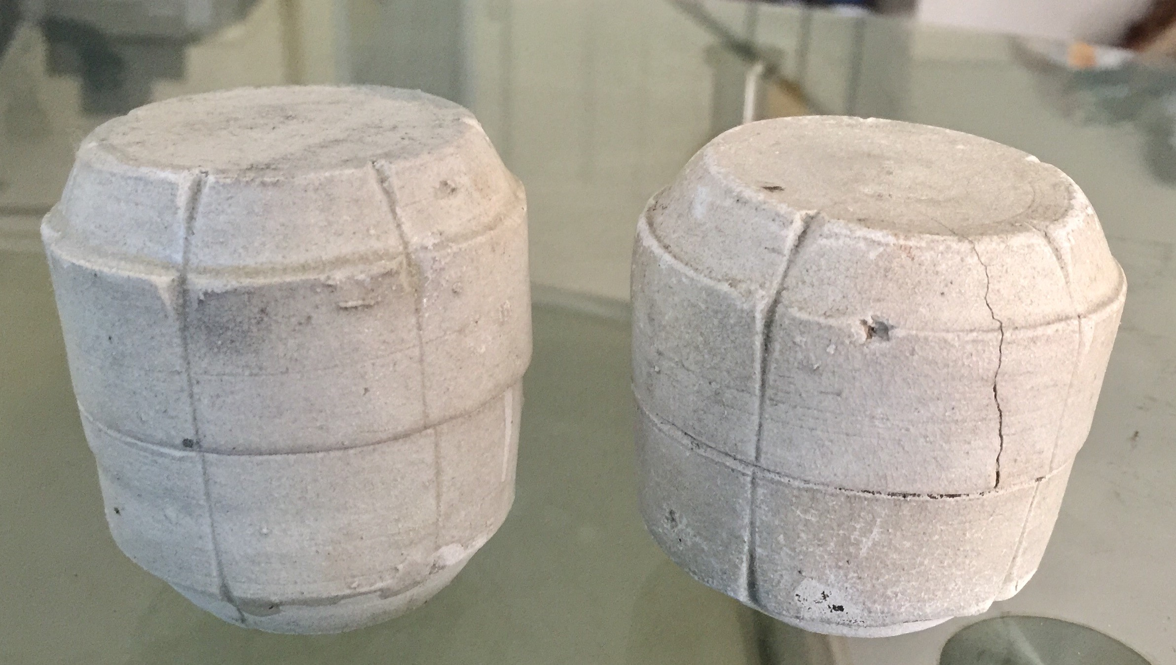 Small cylindrical covered boxes with incised vertical divisions and tapering cover and base.