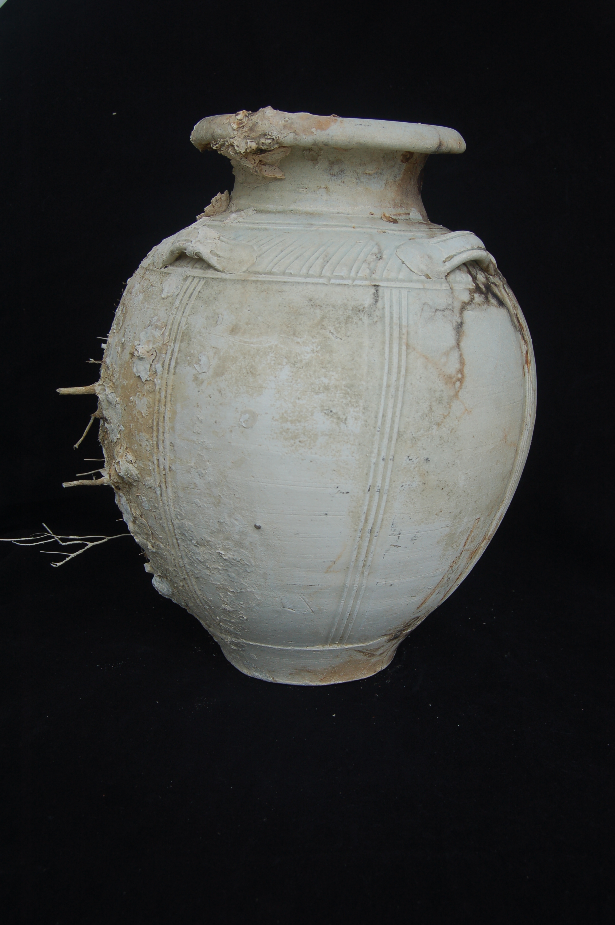 Decorated jar. Gently flared neck with a folded mouth-rim, four lug-handles on the shoulder, and a carved foot-ring. The body is divided into eight panels by triplets of combed vertical lines, while the shoulder is circled by spiral striations. Similar to the previous example although not as refined. Diameter 22 cm, height 30 cm.